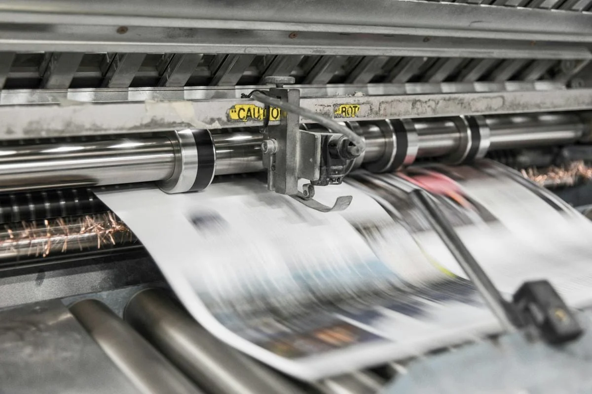 Kranten rollen in hoog tempo van een drukpers in een drukkerij